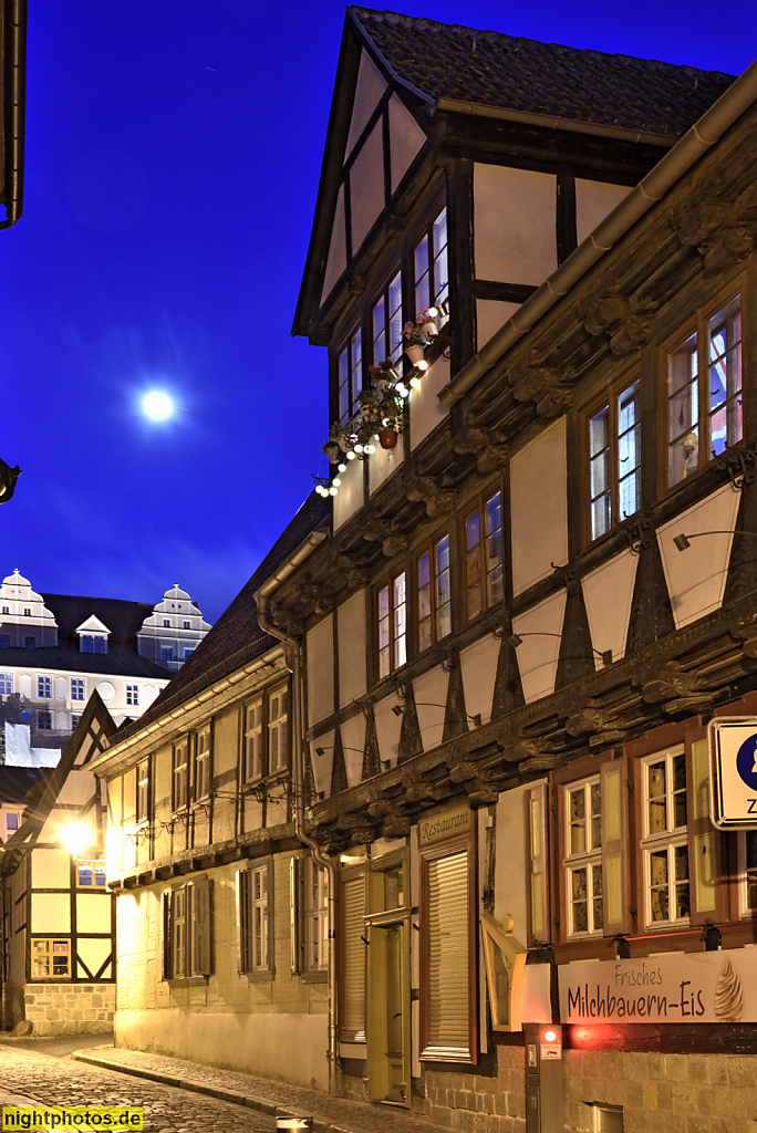 Quedlinburg. Wohnhaus erbaut um 1600. Neubau 1985 hinter historischer Blendfassade mit Zwerchhaus und Konsolfries. Ladenlokal. Hinten Schlossberg mit Stift. Lange Gasse 27